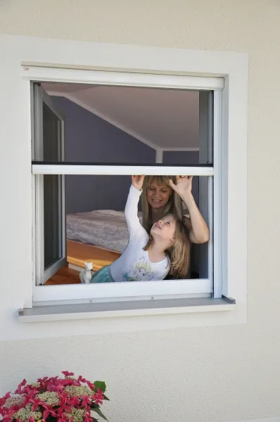 Huber Franz - Insektenschutz - Fenster - Türen – zwei Kinder öffnen begeistert ein Insektenschutzgitter an einem Fenster