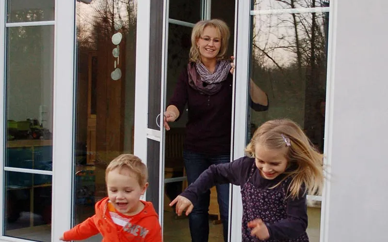 Huber Franz - Insektenschutz - Fenster - Türen – zwei Kinder rennen lachend durch eine Terrassentür nach draußen